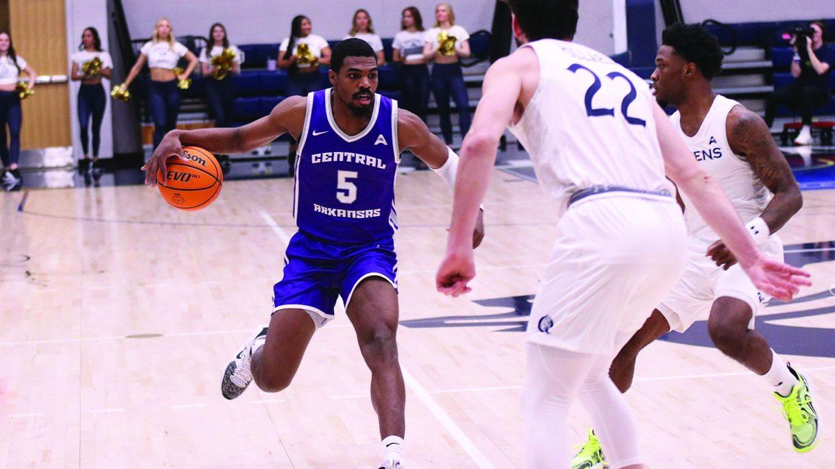 Senior guard Masai Olowokere looks for a way around Queens player junior forward Jaxon Pollard. Olowokere scored the most out of any player on the team, collecting 16 points in total.
