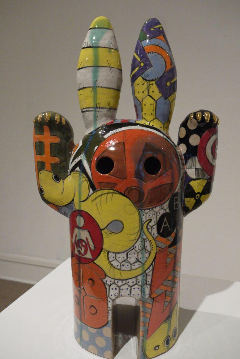 A sculpture at the Baum Gallery exhibit incorporates various patterns and icons.