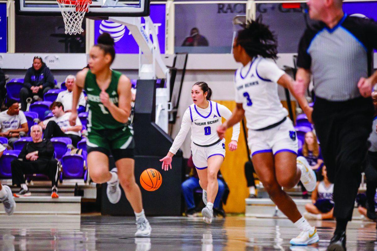 Junior guard Jade Upshaw dribbles the ball as junior guard Randrea Wright looks back at her.