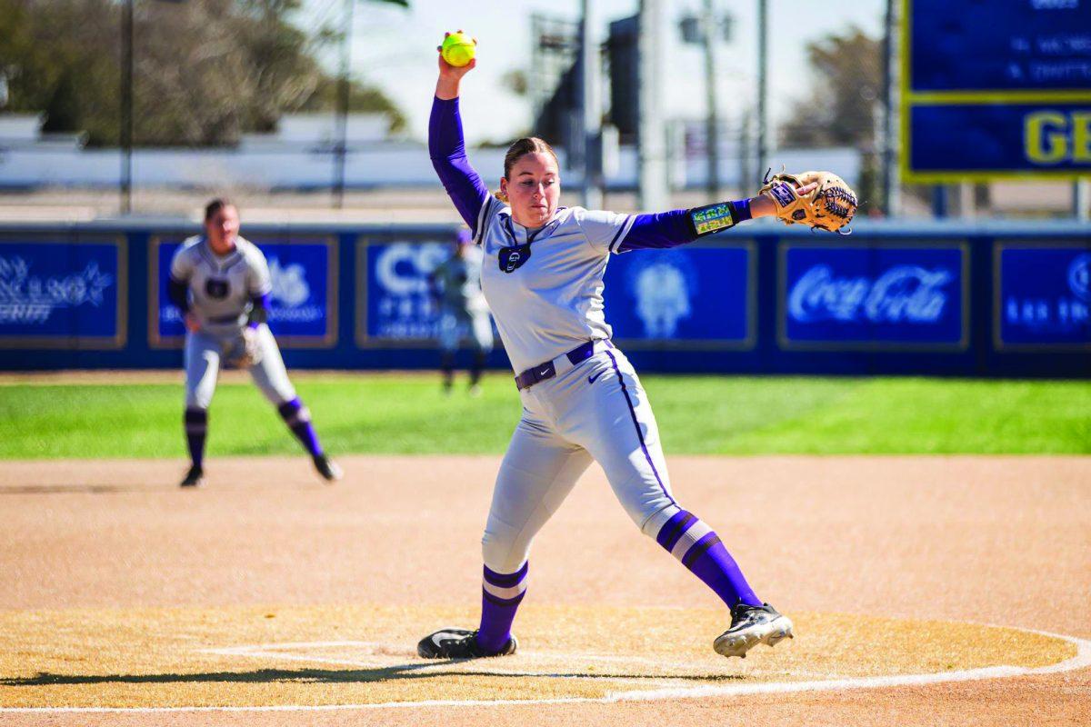 (Bottom) Junior pitcher Bailie Runner lifts her arm to prepare to pitch the ball to an Oklahoma batter.