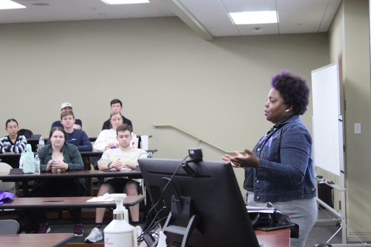 Millie Goins, assistant director of student wellness and programs, presents to students in the College of Business. Goins discussed the importance of both mental and physical wellness.