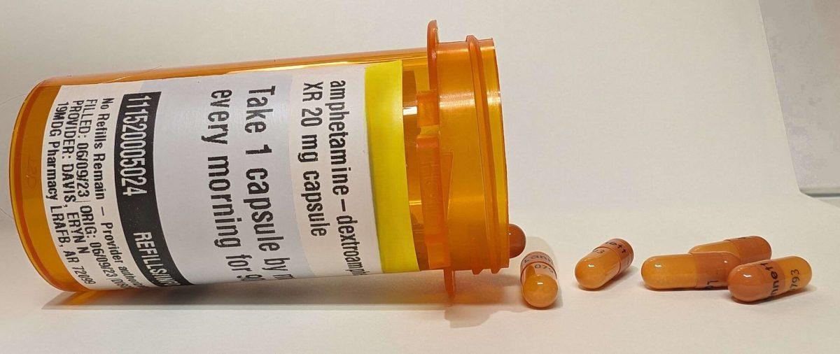 Stimulant medication spills out of an orange pill bottle. The FDA recently announced the nationwide ADHD medication shortage is in its second year.