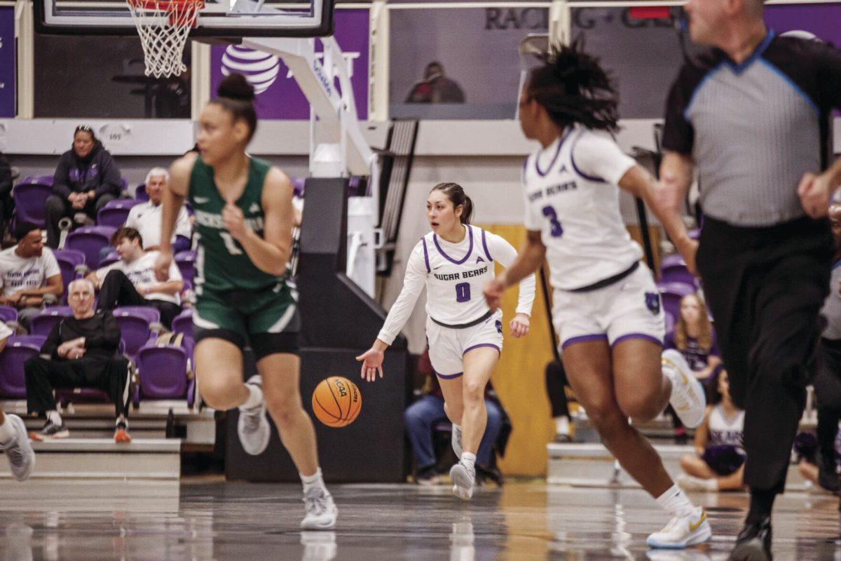 Junior guard Jade Upshaw dribbles the ball as junior guard Randrea Wright looks back at her.