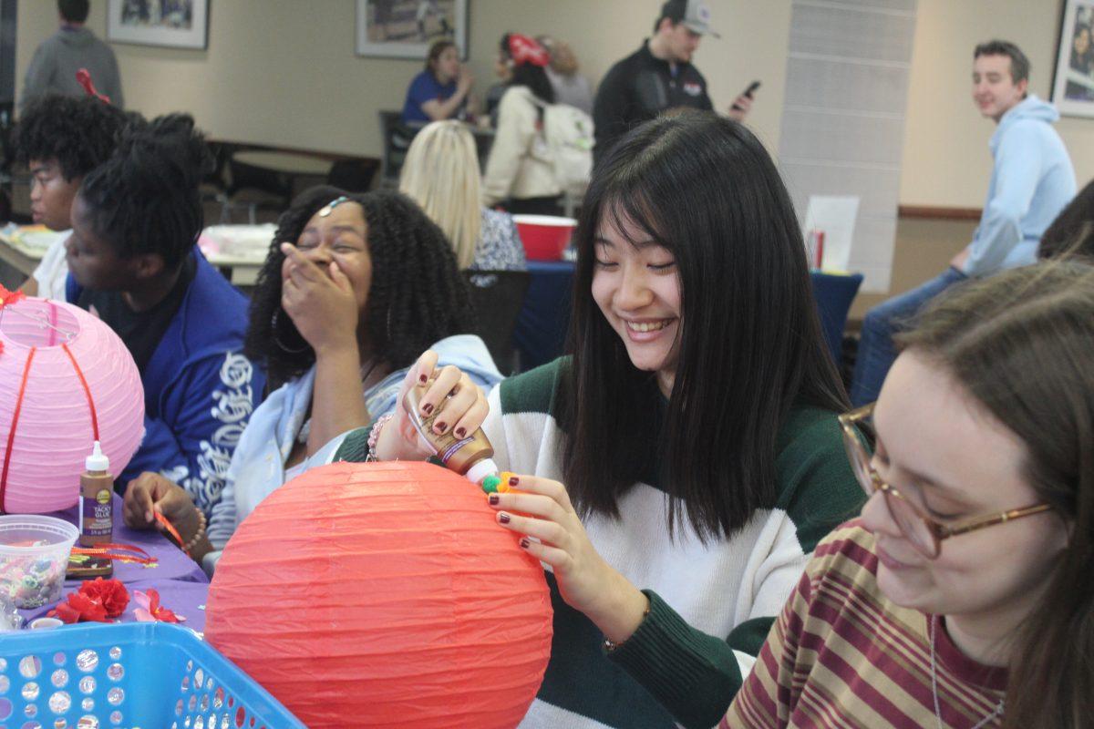 Students decorate paper lanterns at the SAB event. Students had the choice to paint, add beads, use stickers or implement faux flowers when creating their crafts.