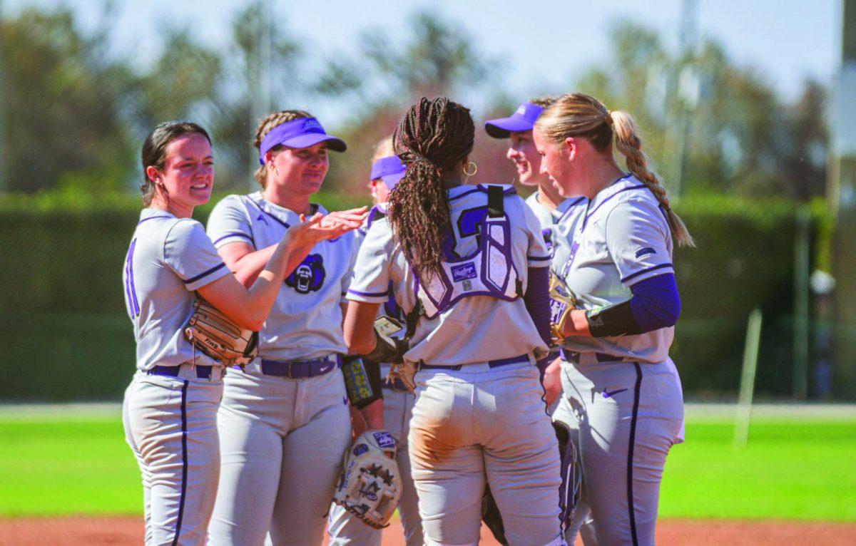 The UCA softball team huddles together on the field. The Bears' first tournament of the 2023 season was the Cowgirl Classic where they went on to win all four of their games.