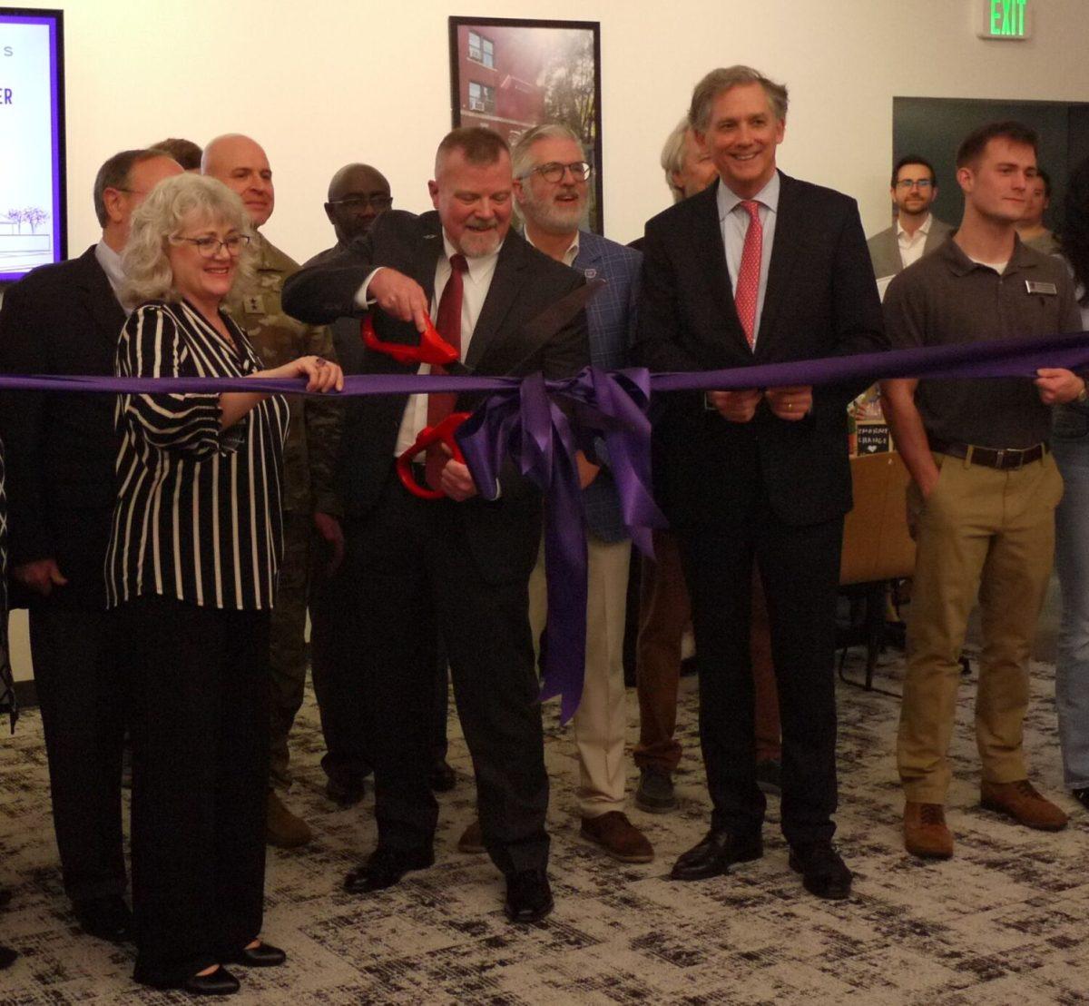 Greg Pelts, Veterans Resource Center director, cuts a ribbon at the opening of the new Student Success and Veterans Resource Center while Director of Student Success Julia Winden-Fey, to his left, holds it. UCA President Houston Davis and Rep. French Hill, to the right of Pelts, attended the ceremony.