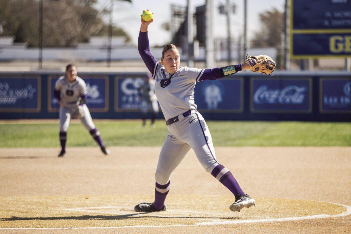 (Bottom) Junior pitcher Bailie Runner lifts her arm to prepare to pitch the ball to an Oklahoma batter.