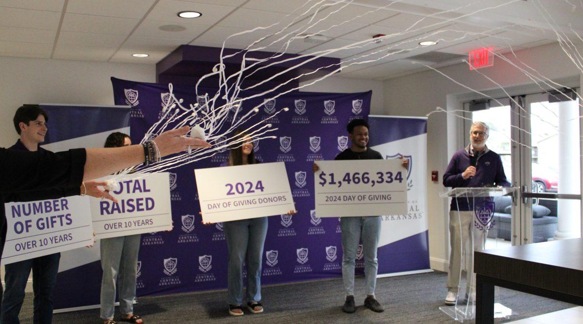 President Houston Davis speaks at the Day of Giving celebration in Buffalo Alumni Hall while students hold signs showing how much money UCA raised. UCA raised a record $1.47 million.