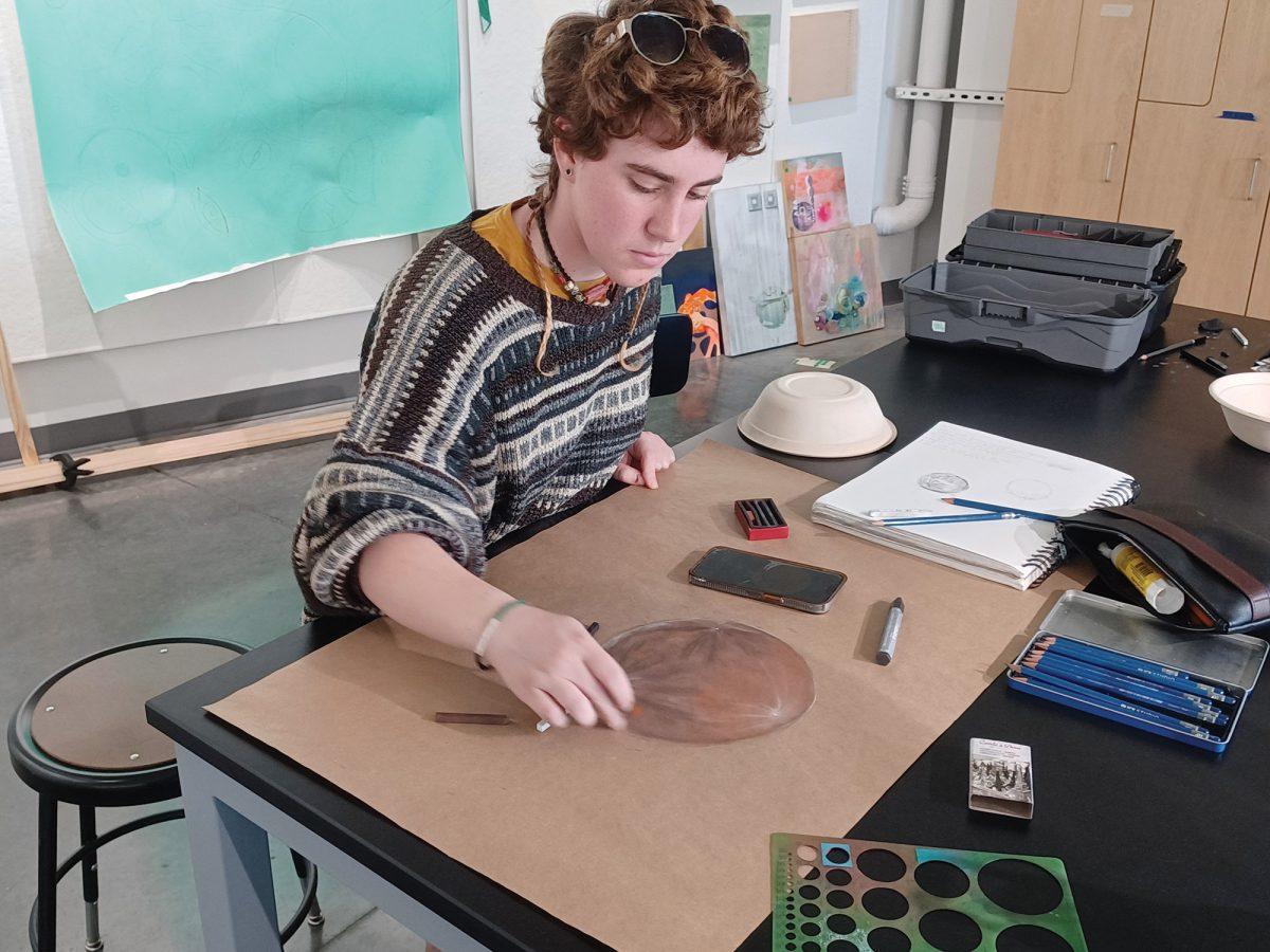 Freshman Beks Jackson adds dimension to their moon drawing.Participants were directed by Russell Crotty, an internationally renownedartist.