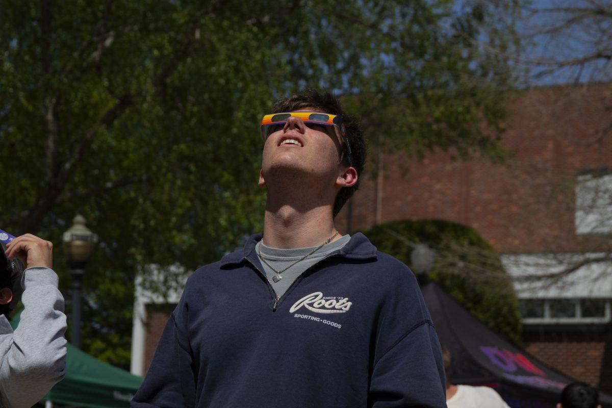 A man looks up at the sky with eclipse glasses. Visitors from across the state and country came to UCA's eclipse-viewing party at Estes Stadium.
