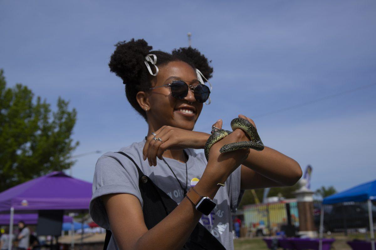 Student Erin George holds a speckled king snake. The Green Bear Coalition had the snake at its booth at the viewing party.
