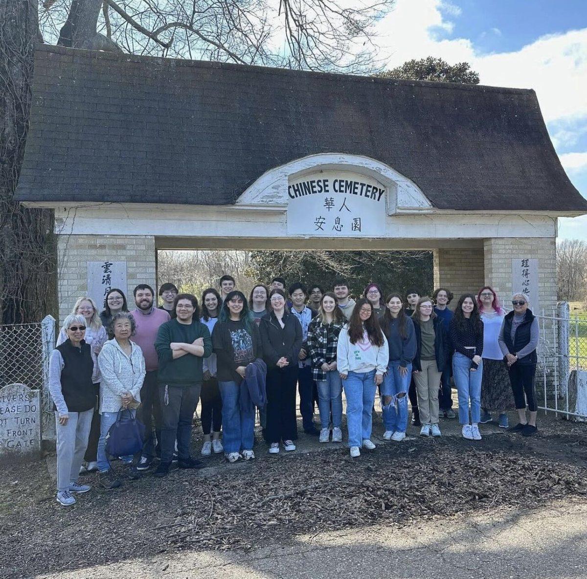Zach Smith and his students pose in front of a Chinese cemetery. Smith said it is important to learn the unheard stories of Chinese communities in the South.