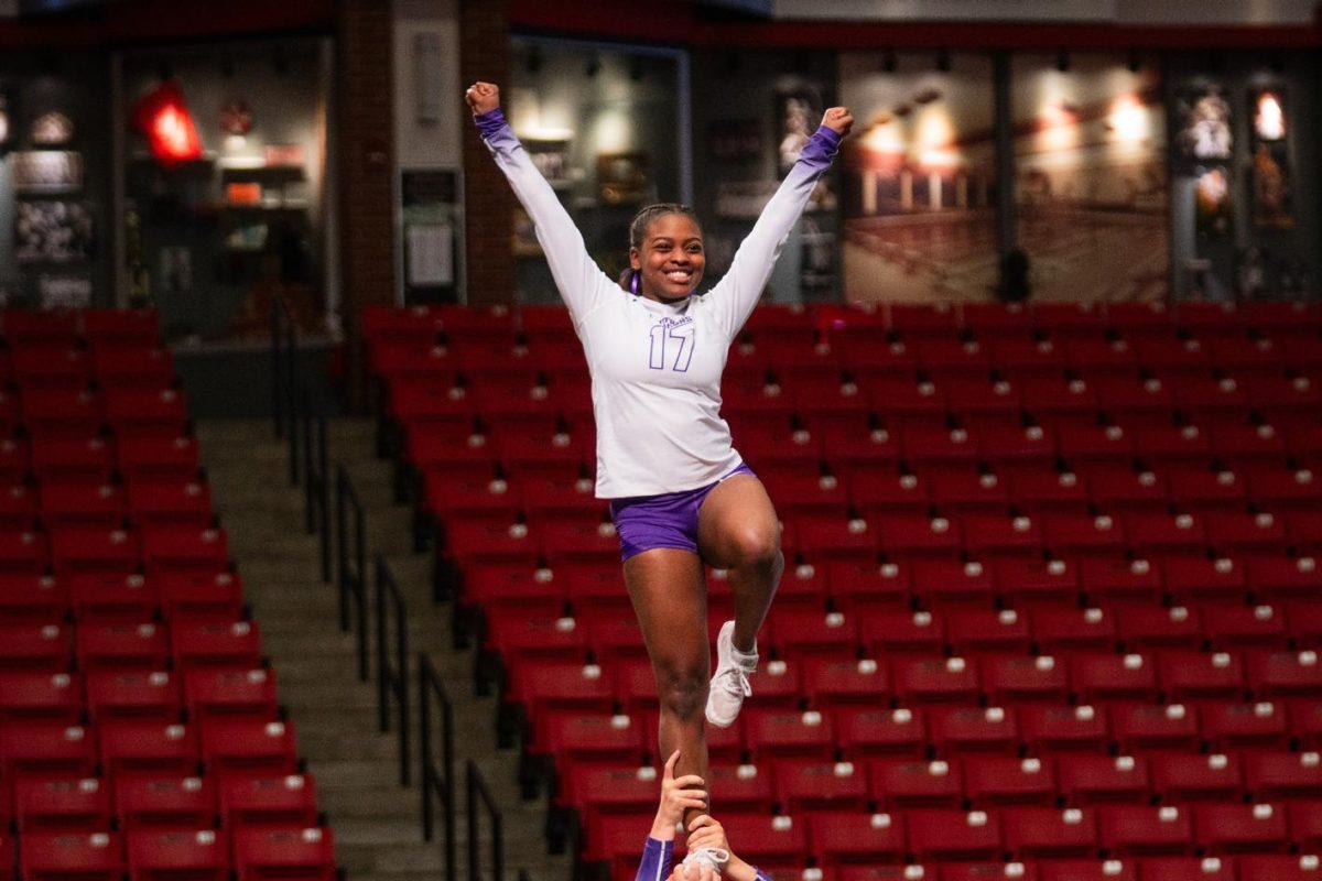 Sophomore flyer/tumbler Sajala Bell raises her arms as her teammates hold her up in the air. The April 6-7 tournament marked the end of the STUNT team's regular team.