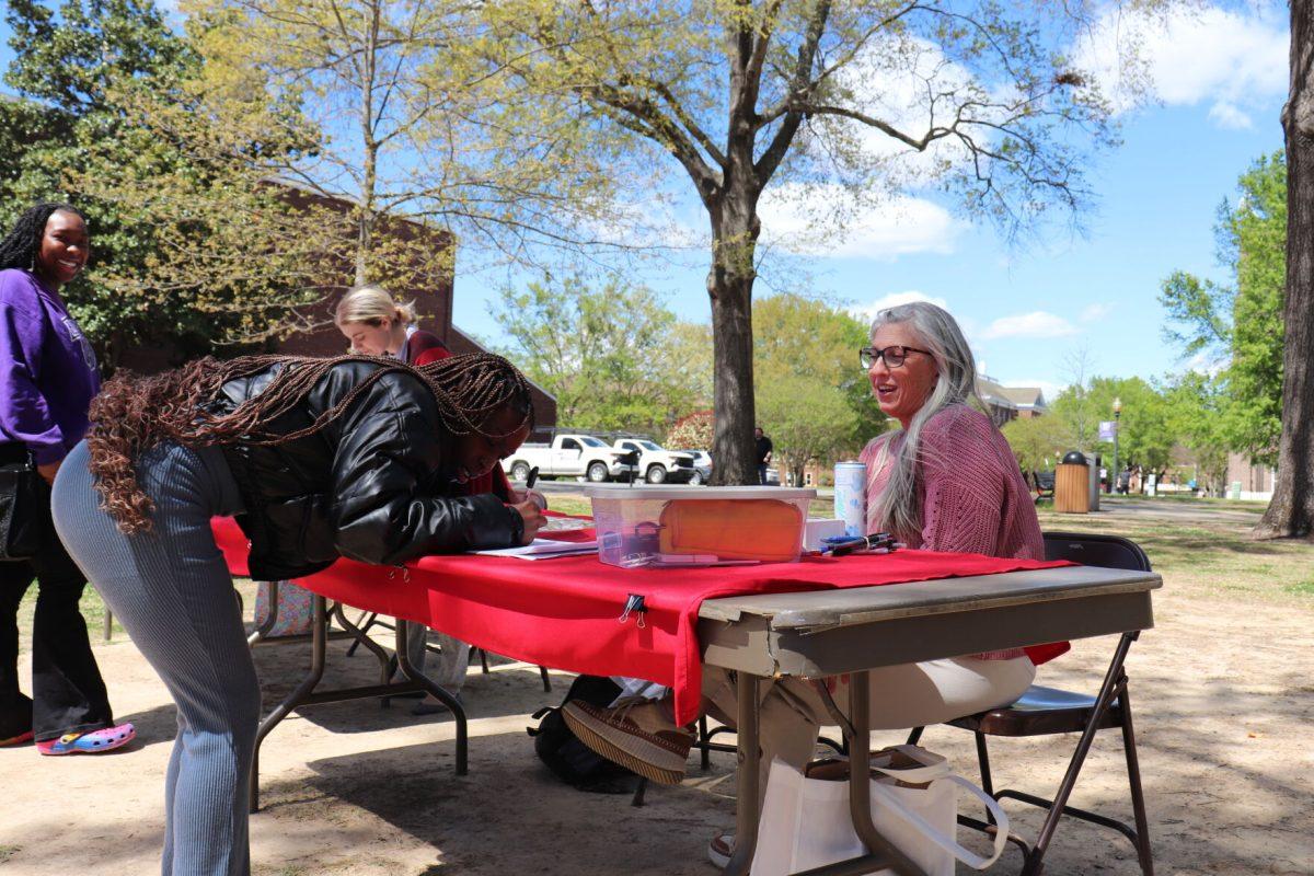 Freshman nursing major Zamiria Otey signs a petition at the Ballot Initiative Fair on April 3. Students could also register to vote at the fair.