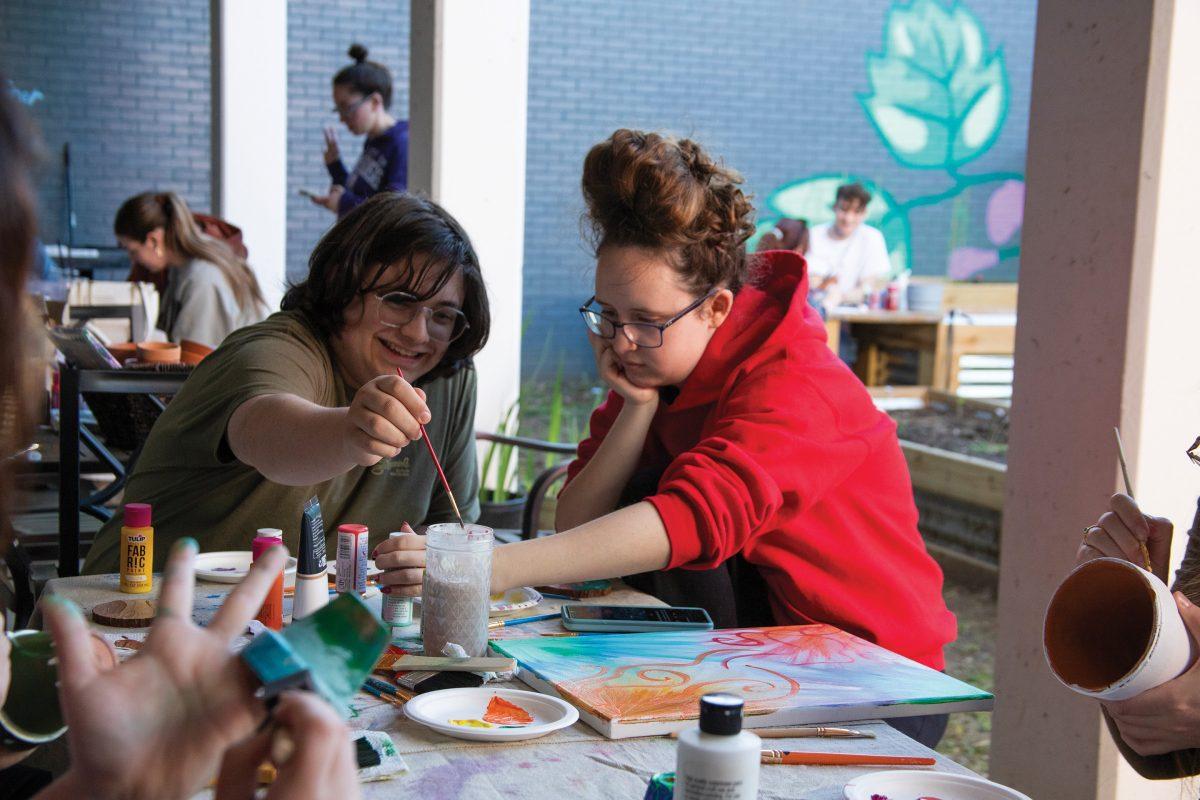 Two students paint pots at an event hosted by Allies in STEM and Green Bear Coalition. The event aimed to help students relieve stress.  