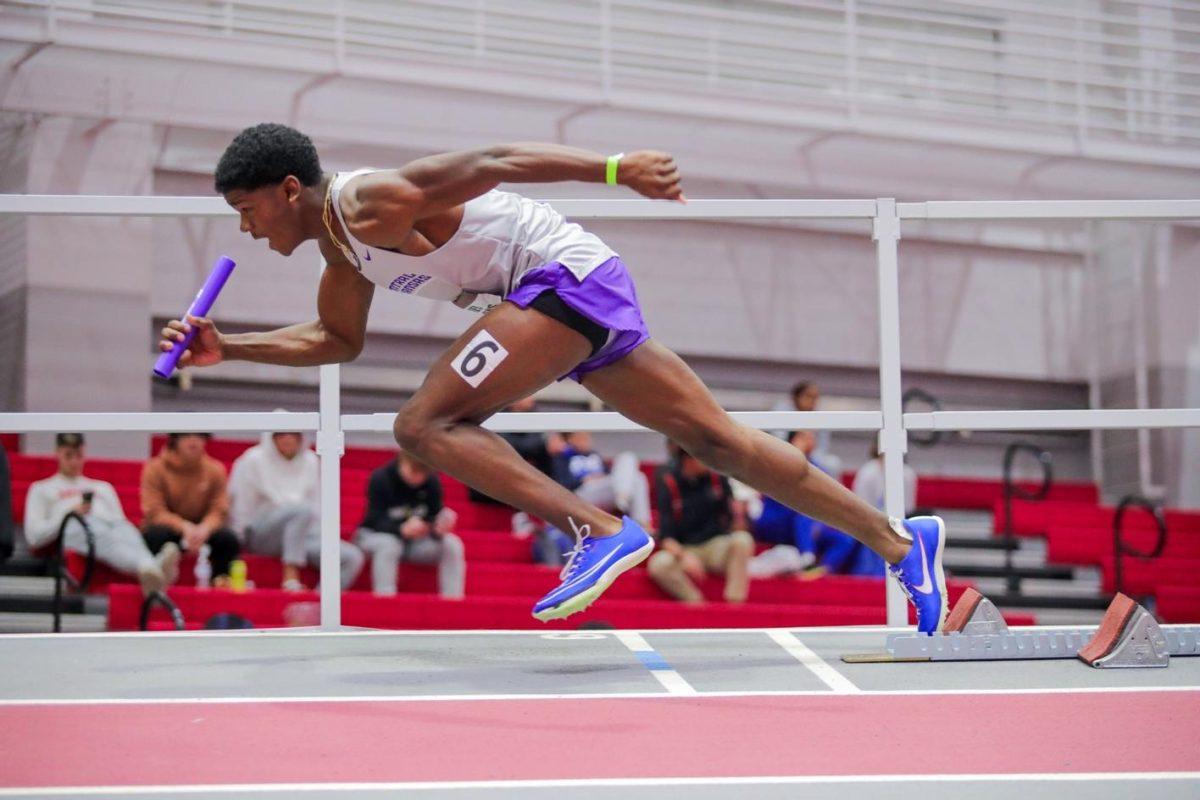 Freshman Xavier Simpkins launches off of the starter block with a purple baton in his right hand. In high school, Simpkins was a five-time state champion, Penn Relay champion and a Texas Relays finalist. 