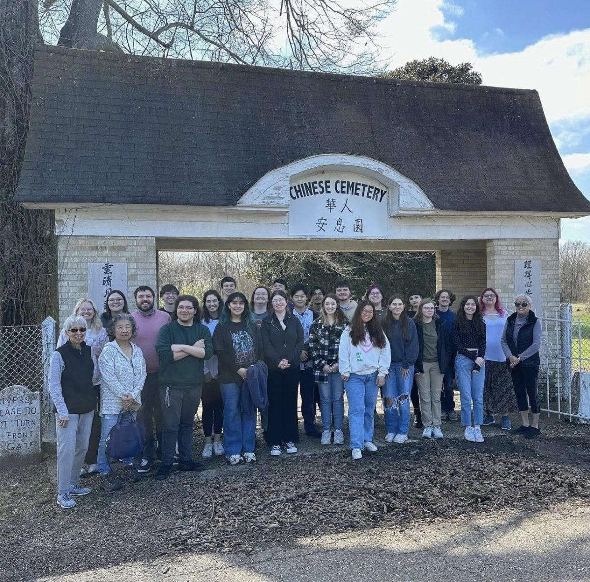 Zach Smith and his students pose in front of a Chinese cemetery. Smith said it is important to learn the unheard stories of Chinese communities in the South.