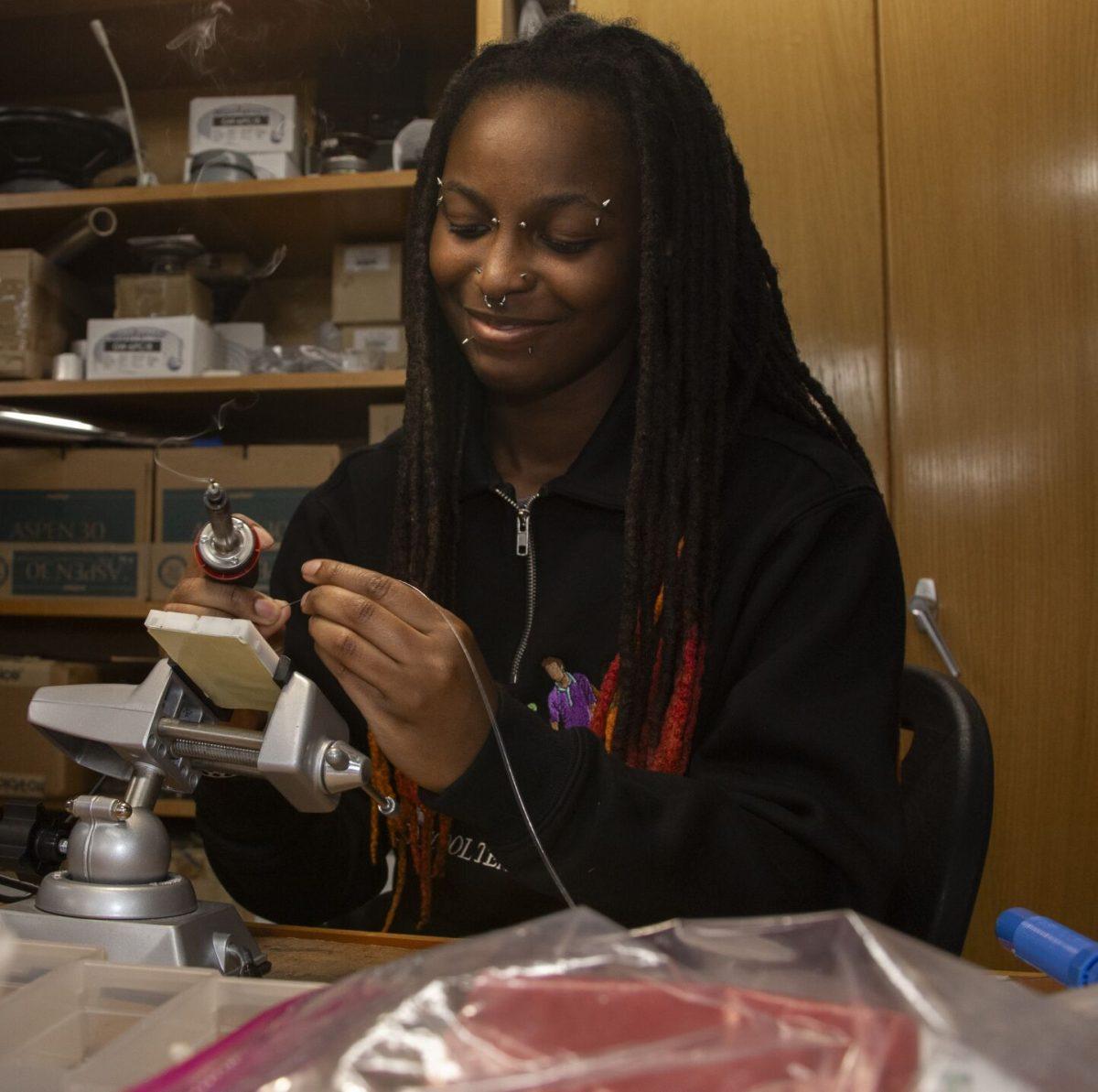 Honey Norfolk, a sophomore double majoring in engineering physics and sociology, uses a soldering iron on a Raspberry Pi Pico. Norfolk started working in February to finish the boards in time for the eclipse.