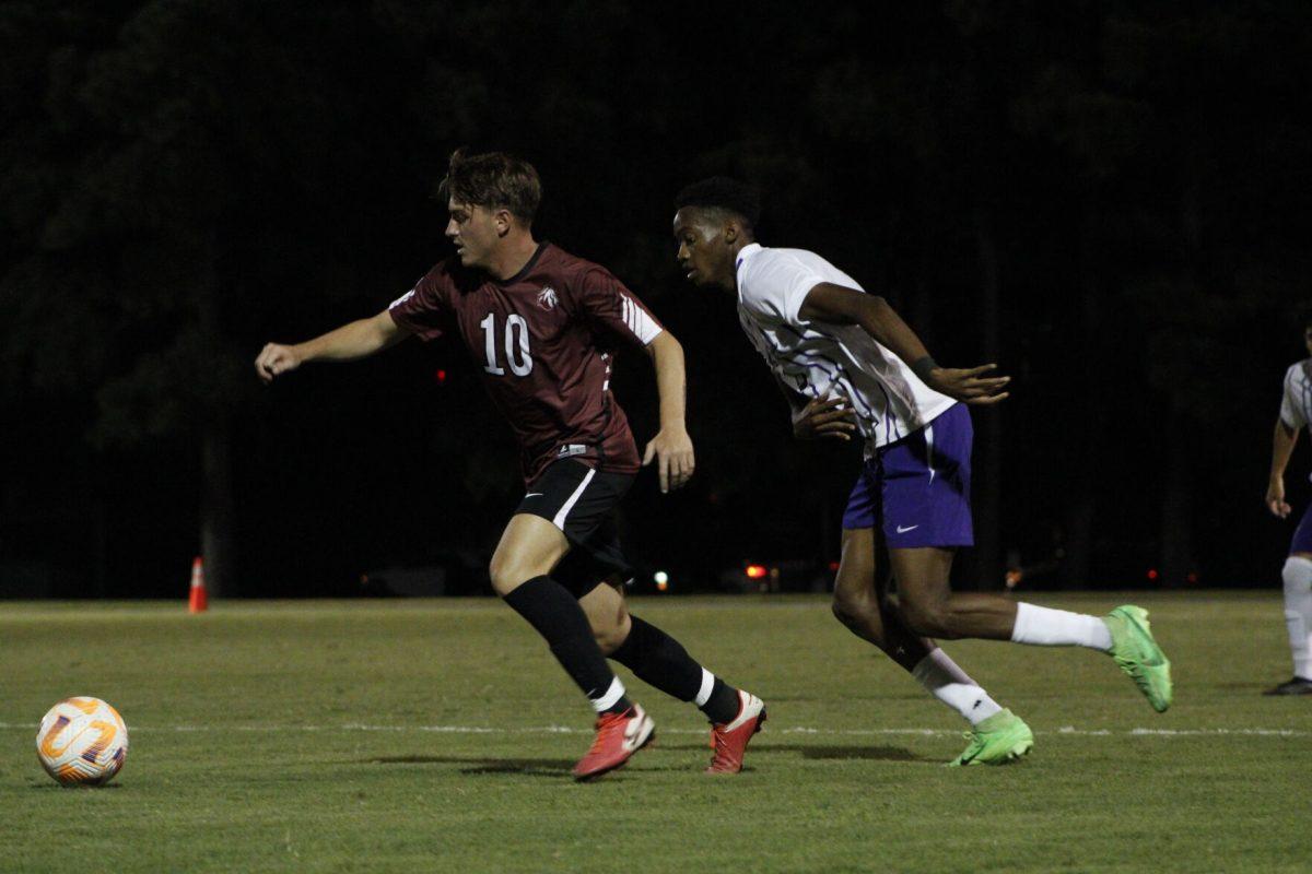 Evangel junior forward Andrea Fincato and UCA Freshman foward/midfielder Devonte Richards race for the ball. 