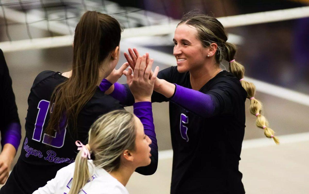 Senior outside hitter Lilly Taylor gives a high five to junior setter Caylan Koons. Last season, the Sugar Bears had a seasonal record of 8-20.