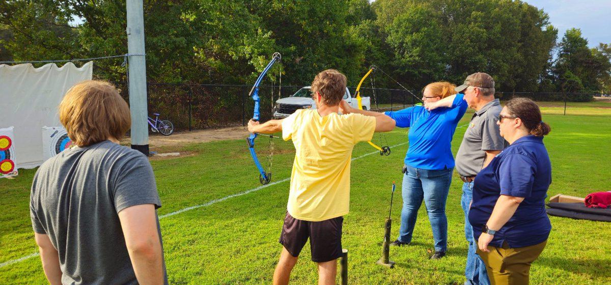 Students practice archery during an information session about hunting. Hosted by the Arkansas Game and Fish Commission, participants gained insights on hunting and conservation. 