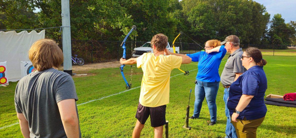 Students practice archery during an information session about hunting. Hosted by the Arkansas Game and Fish Commission, participants gained insights on hunting and conservation. 