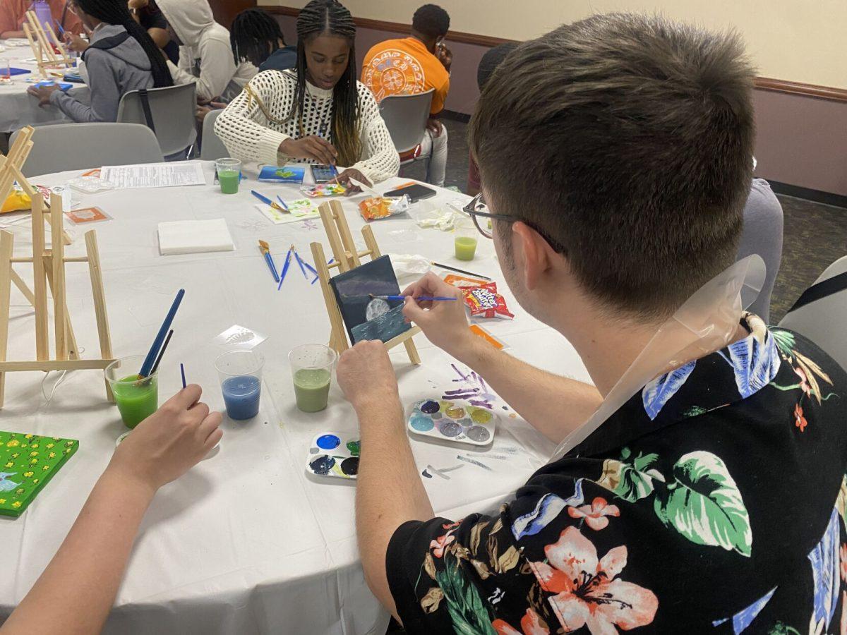 A student paints a moon rising over the sea Sept. 17 at UCA F1RSTs’ Canvas Creations.