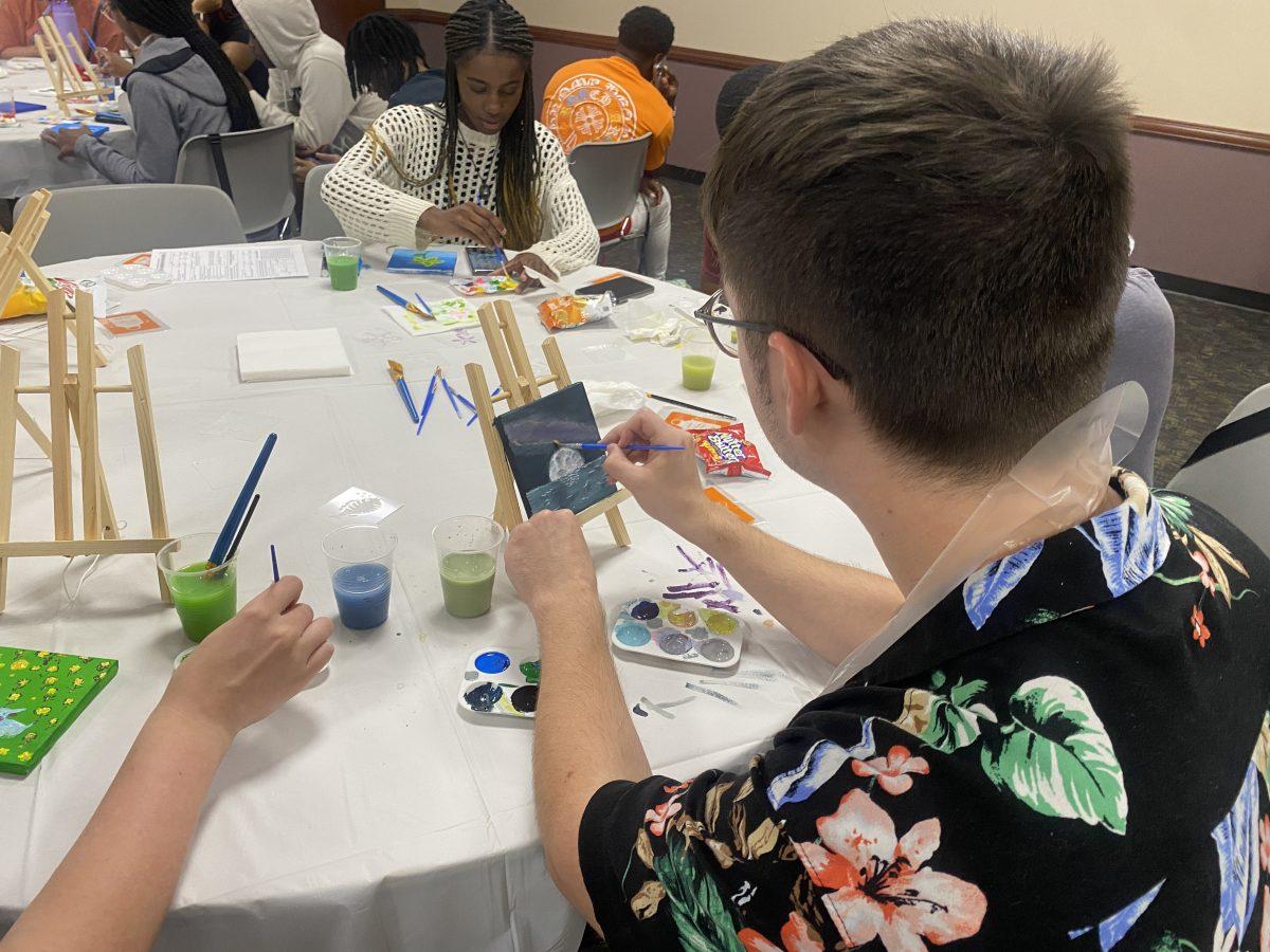 A student paints a moon rising over the sea Sept. 17 at UCA F1RSTs’ Canvas Creations.