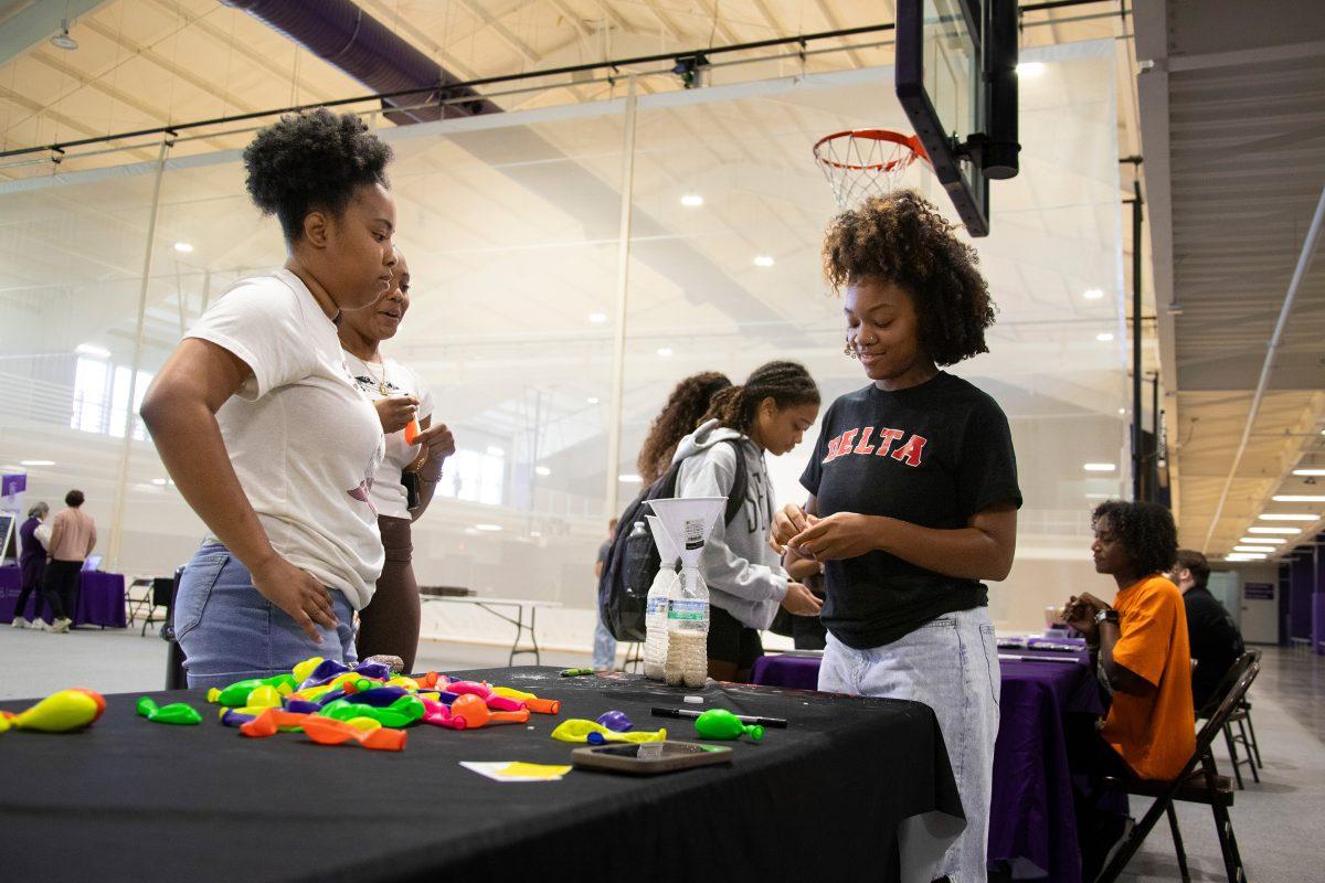 Two students stand at the Delta Sigma Theta booth to learn about wellness. The wellness fair was held Oct. 3 at the HPER.