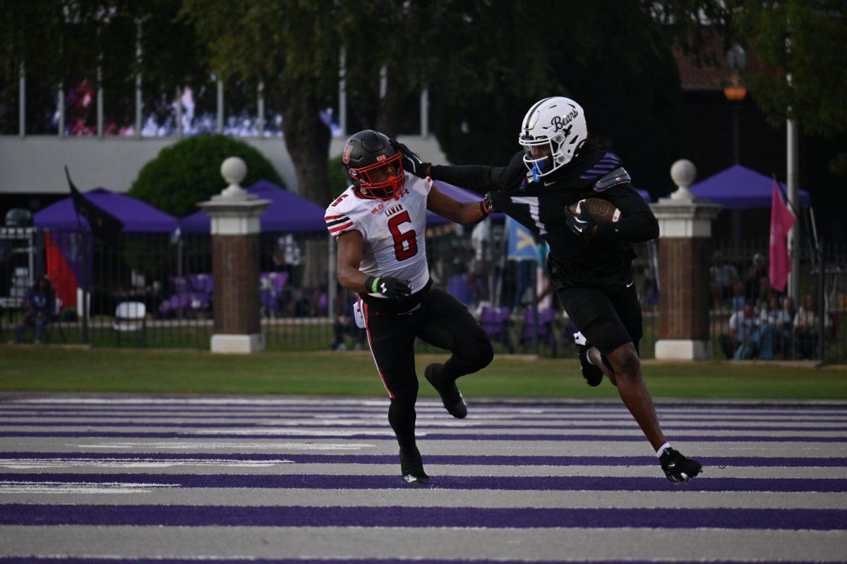 (Right) Senior defensive back TaMuarion Wilson returns an interception while stiff-arming senior runningback Khalan Griffin. This was Wilson’s second interception of the season, totaling 39 yards.(photo by Meredith Lipsey)