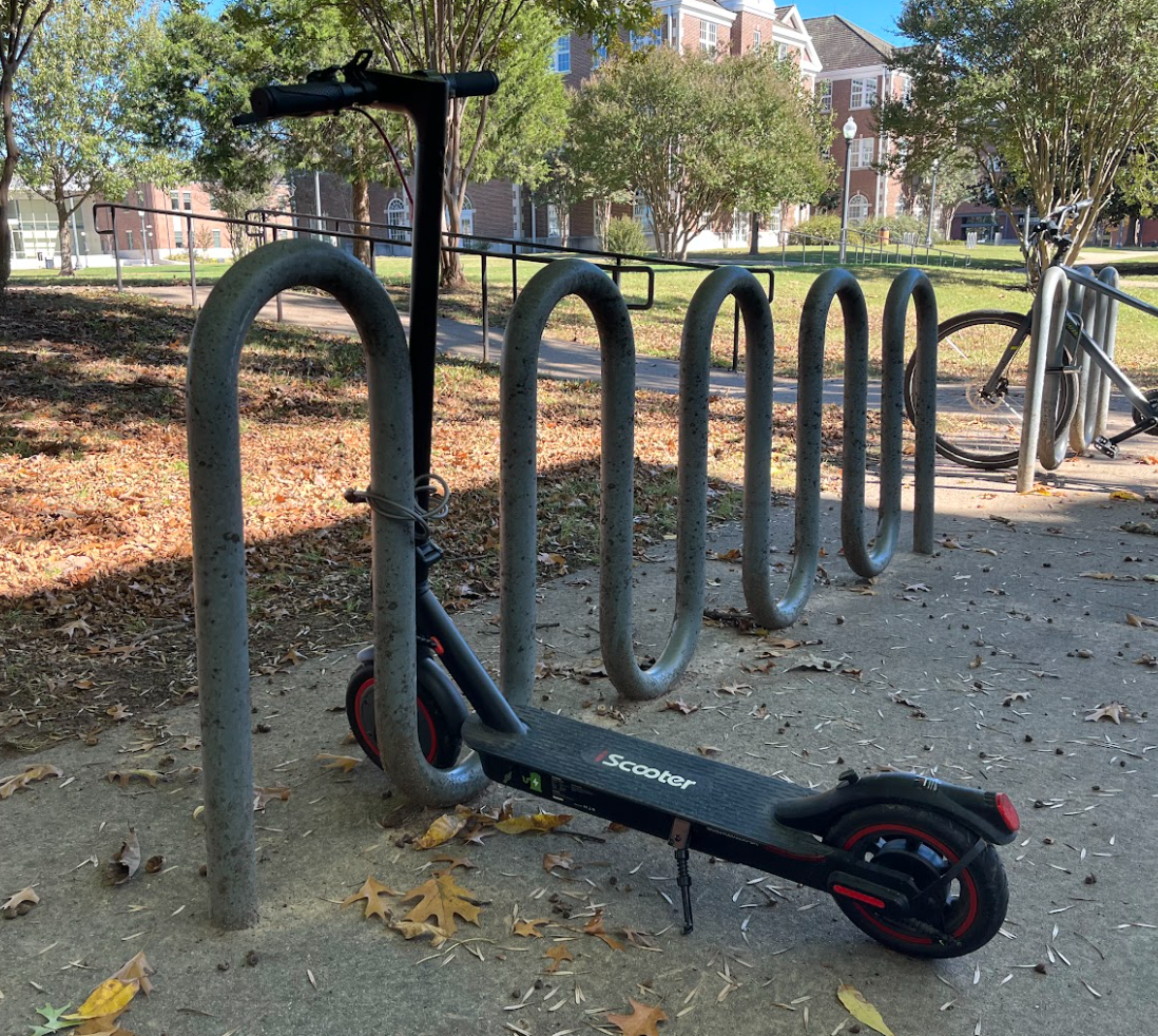 A scooter sits at a bike rack by Irby Hall. Since the reinforcement of Board Policy 423, students have been locking their scooters to bike racks. 