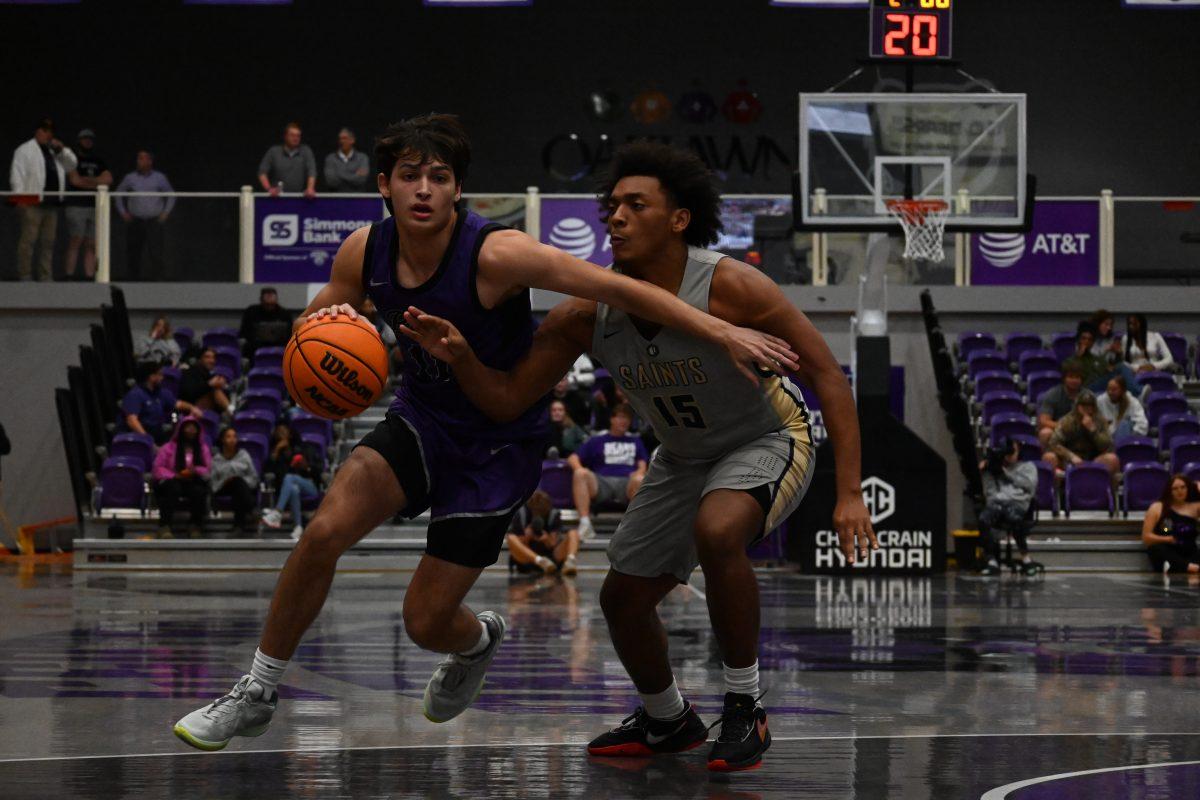 Freshman guard Connor Mancell fends off sophomore forward Braxton Peterson. Mancell went 0-1 inthe 108-49 win against the Saints.