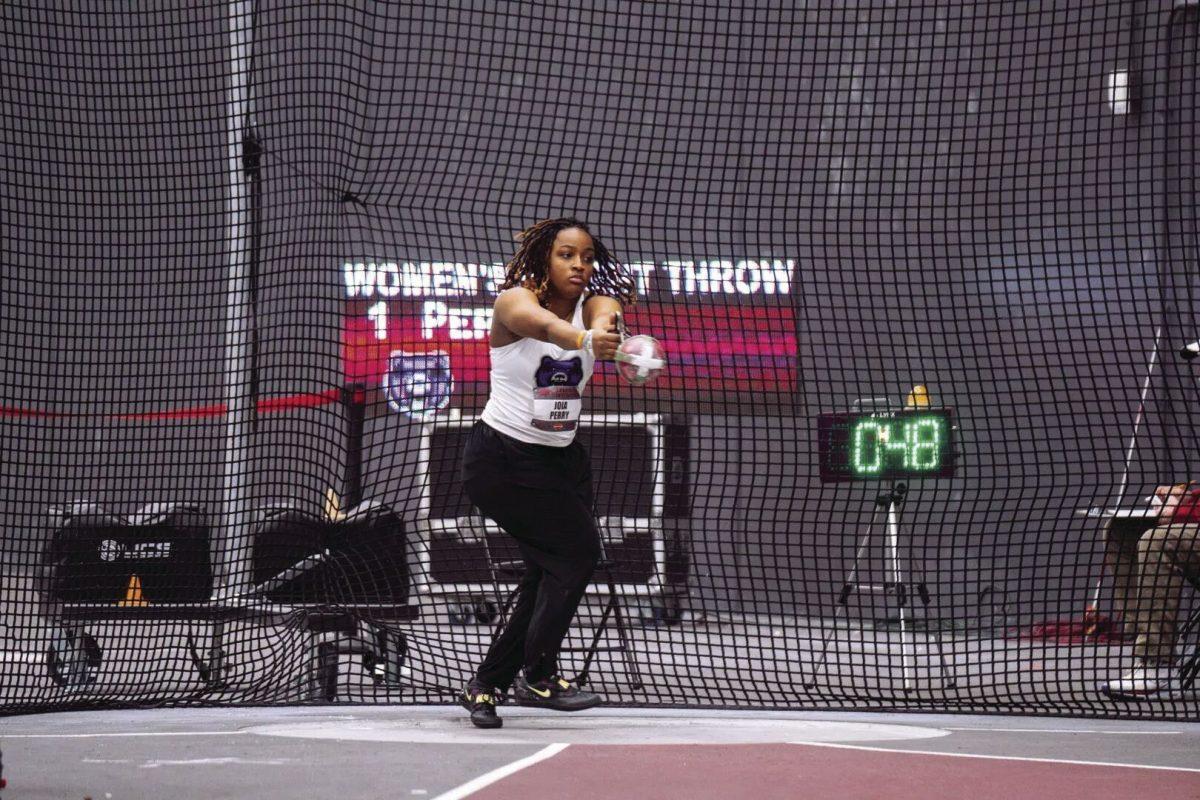 Senior thrower Joia Perry builds up momentum to complete the weight throw at the Washburn Open. Perry threw a personal record of 18.69 meters.