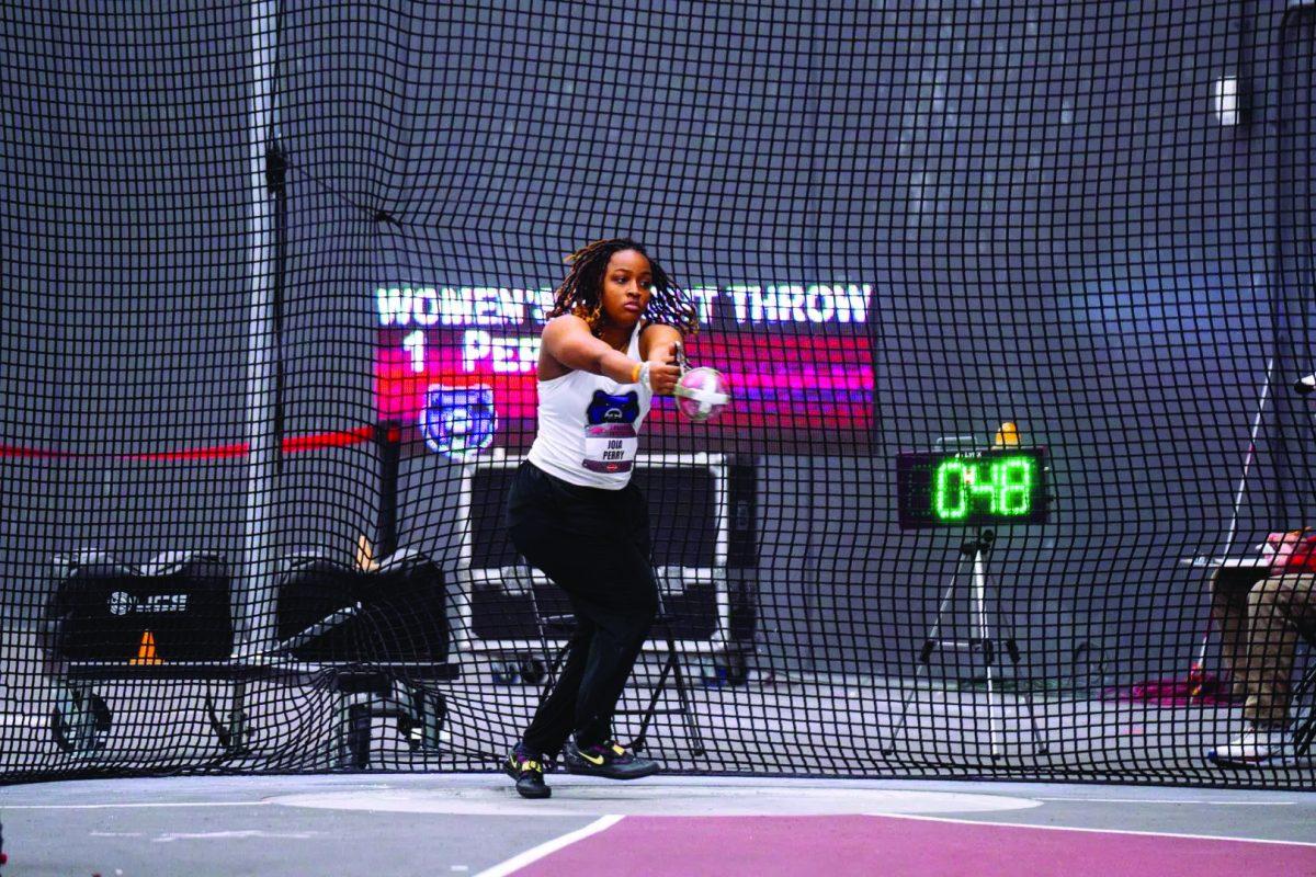 Senior thrower Joia Perry builds up momentum to complete the weight throw at the Washburn Open. Perry threw a personal record of 18.69 meters.