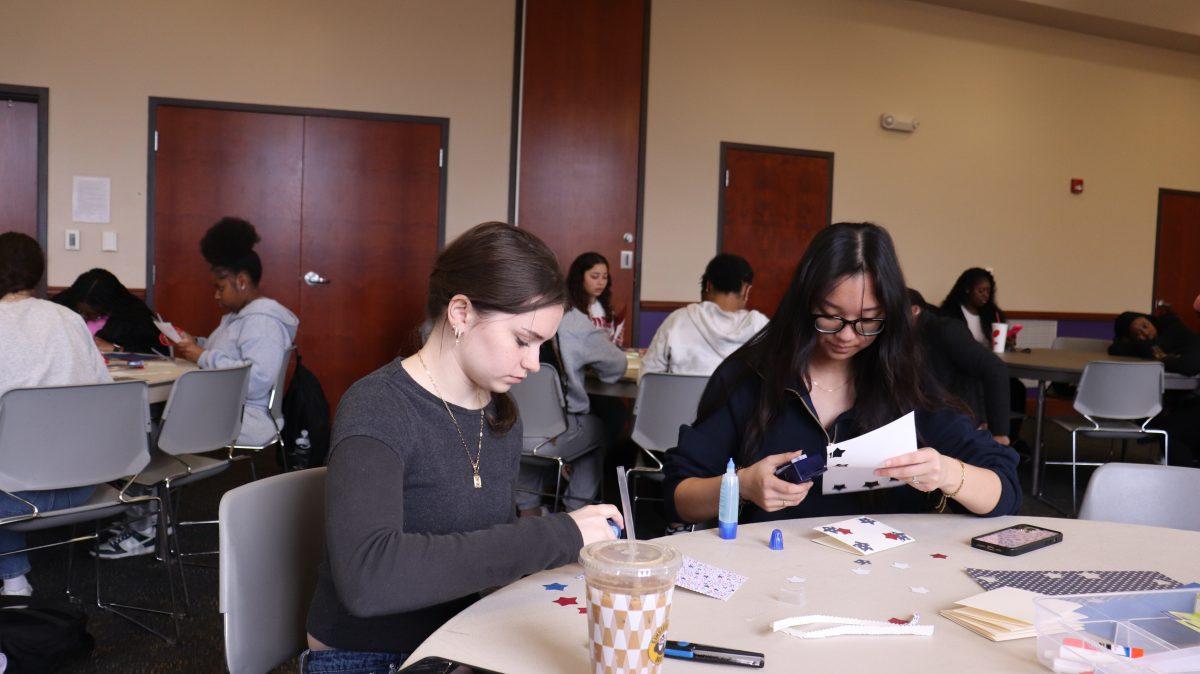 Freshman Grace Edwards and freshman Judith Wanasida crafting thank you cards for service members. Students were able tovolunteer, and make cards at this event.