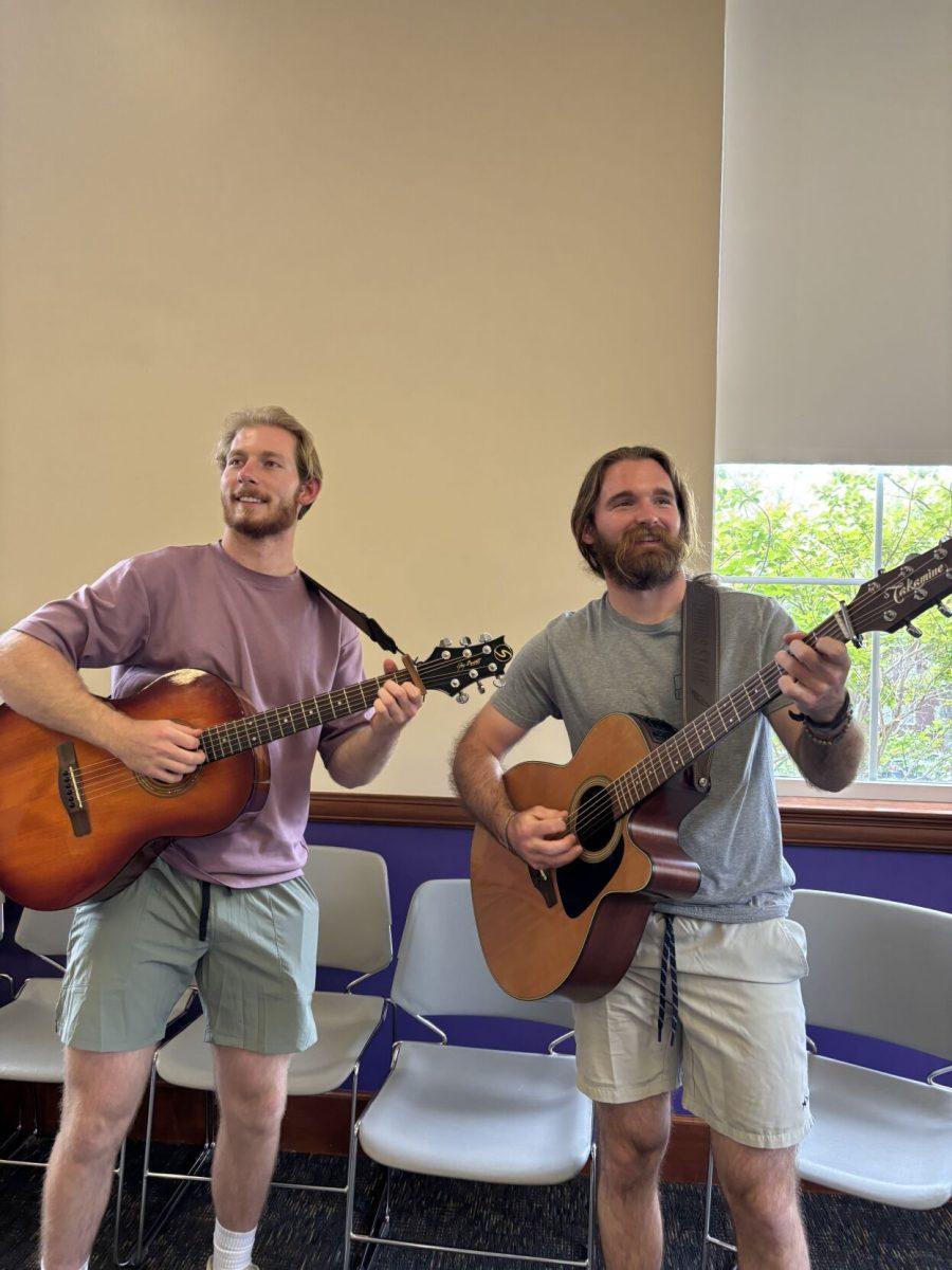 (Left to right) Sam Carlisle and Parker Stane play guitars at the honors
art show. This event also consisted of poetry and art.