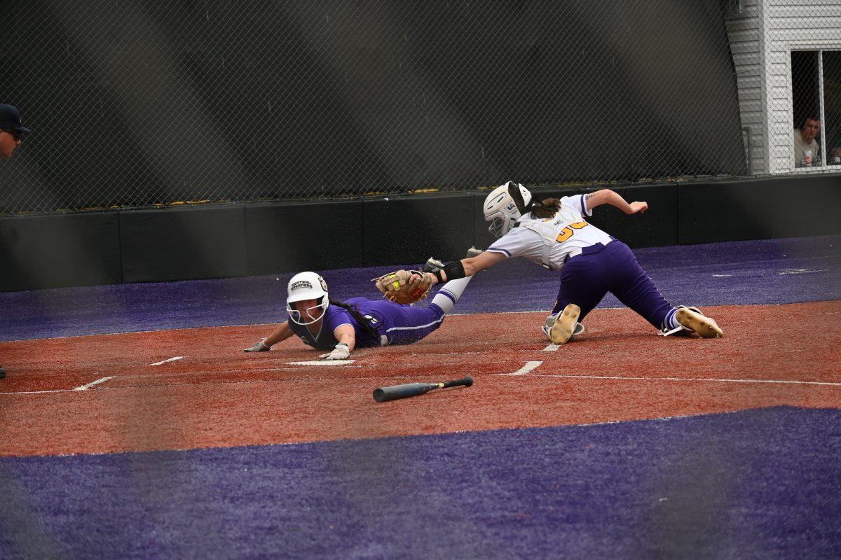 Freshman center fielder Addie Graham dives for home plate after running from first base to score for the Bears, dodging the tag from sophomore catcher Brenna Sherman. Graham has scored 39 runs in her debut season for the Bears.
