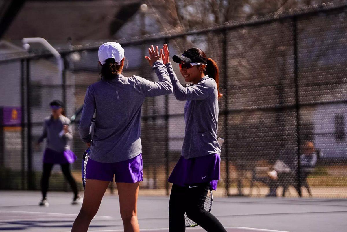 Freshman Nanami Fukushima high-fives her doubles partner, junior Ting-An Chen, during their doubles match against UNA duo Ada Karabacak and Lena Karlovcan. UCA's duo won this match 6-1. 