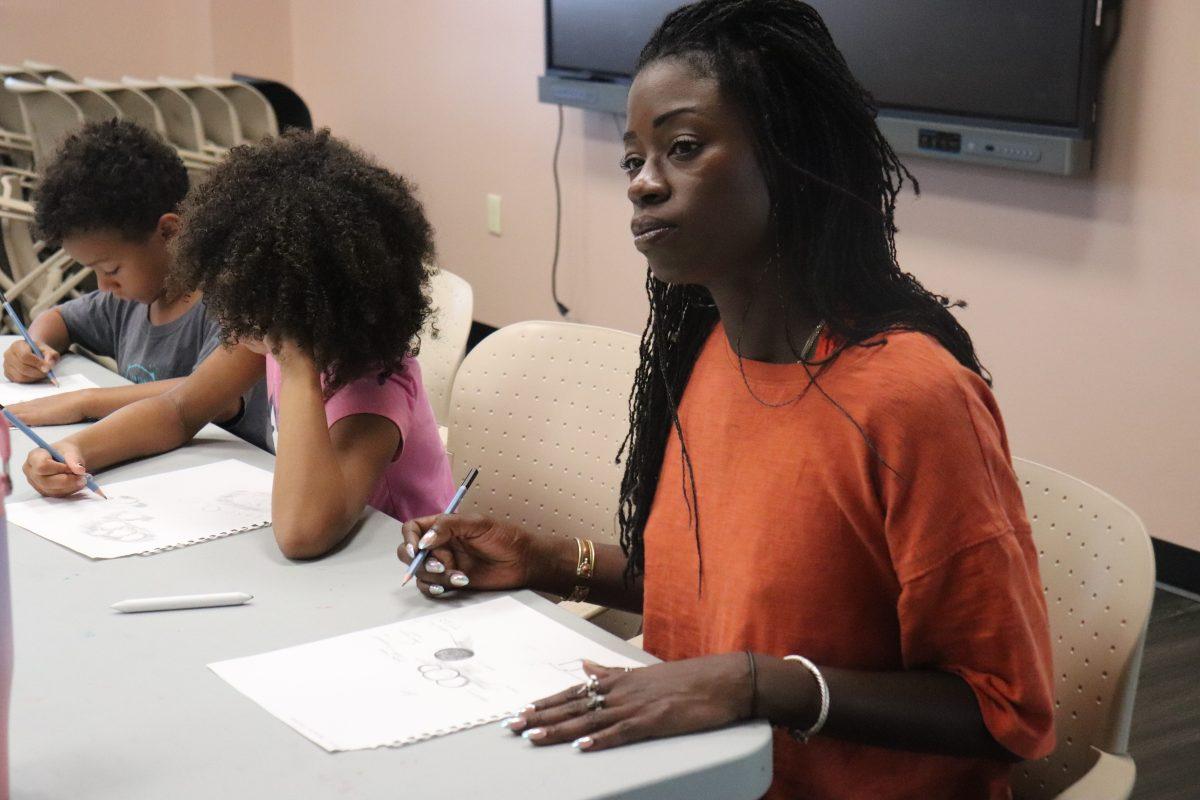 A beginner artist ponders her next sketch amongst other event attendees. (photo by Mary Lyle)
