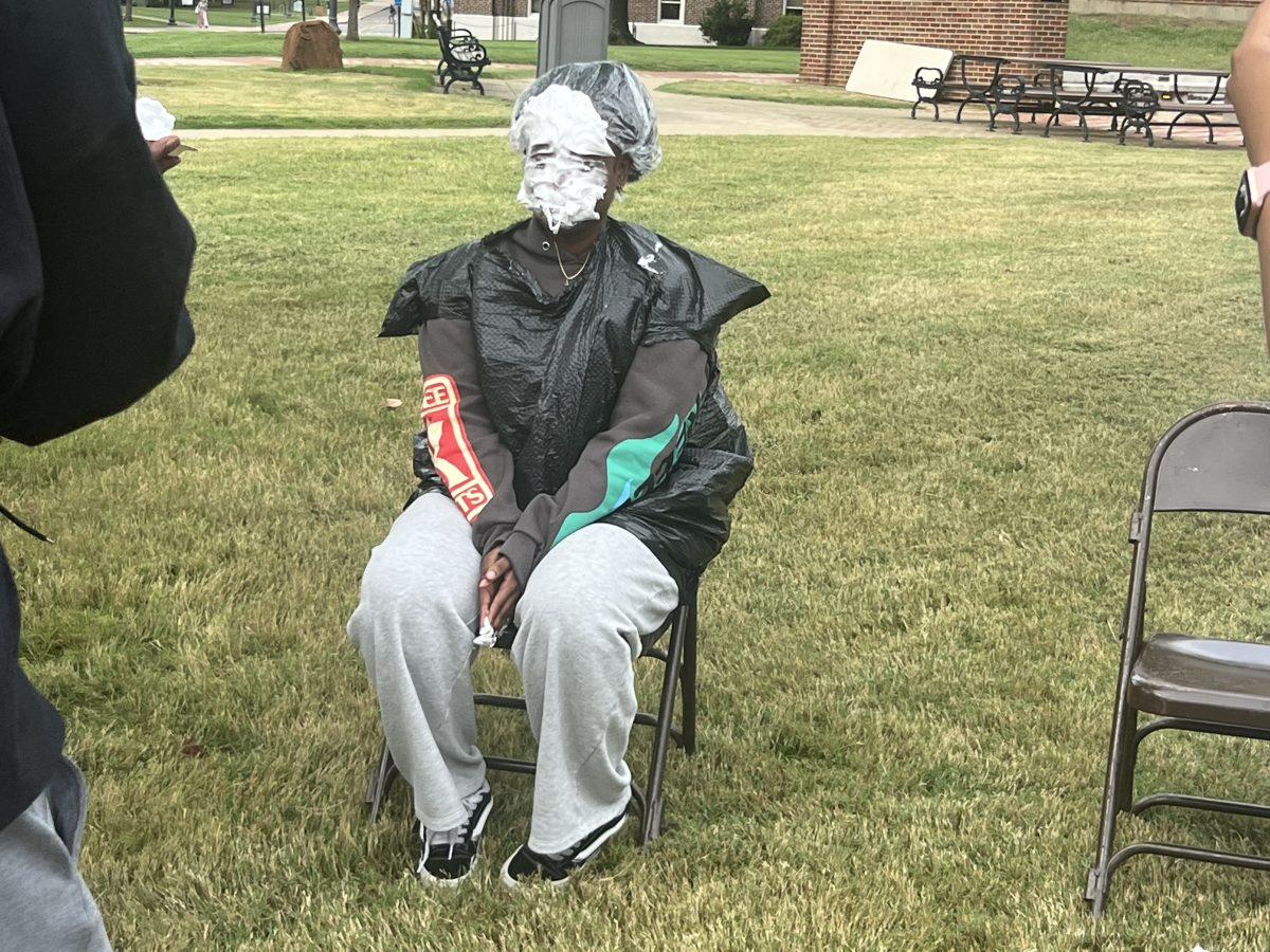 An executive member of Real Beauty sits after being pied in the face. Real Beauty hosted the "Pie an Exec" event to raise money for the organization.