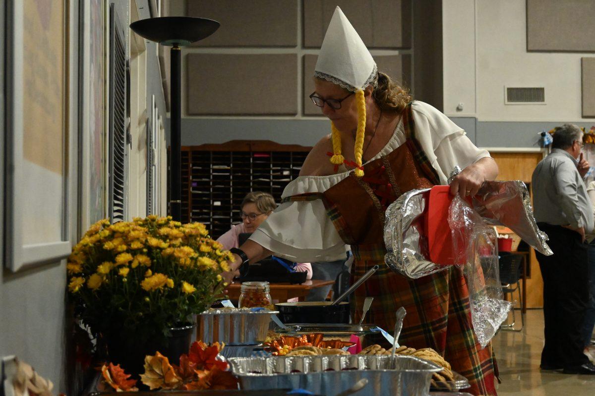Jenny Bruenger sets up the dessert table. She's also wearing Lederhosen which is a cultural German attire. (photo by Meredith Lipsey)