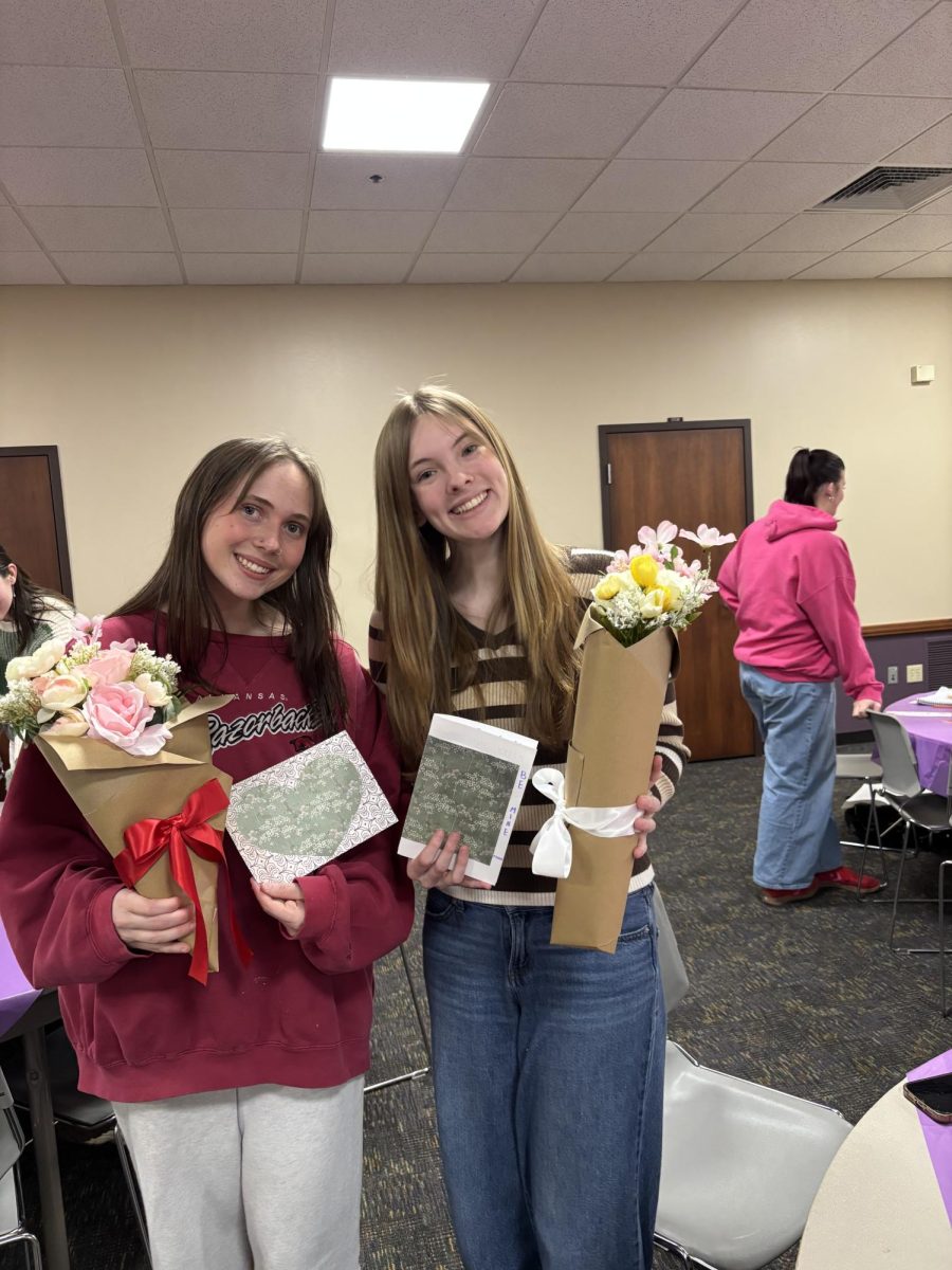 Olivia Smith (left) and Eva Benson (right) pose with cards and bouquets of flowers they made at "Petals and Letters." The host organizations of the event were the Feminist Union and the Student Staff Network. 