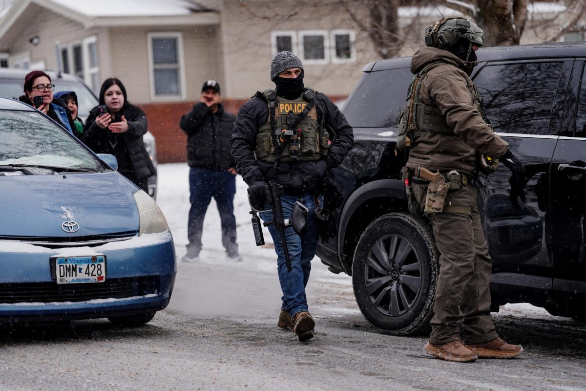 People react and record with their phones while ICE agents and other law enforcement officers detain a man after conducting an immigration raid at his home in St. Paul, Minnesota, U.S.
REUTERS/Leah Millis
