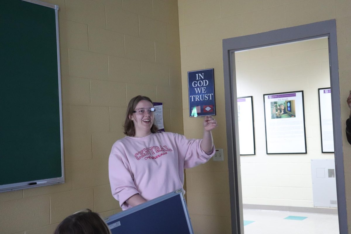 ACS vice president and junior chemistry major Hailey Zornes demonstrates a green flame at the RSO's monthly meeting March 10. The flame's green color was due to a methanol solution applied to the sticks. 